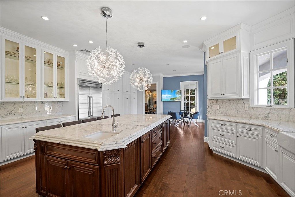 Kitchen with walnut island and glass-front cabinetry at 22510 La Quilla Dr, Chatsworth