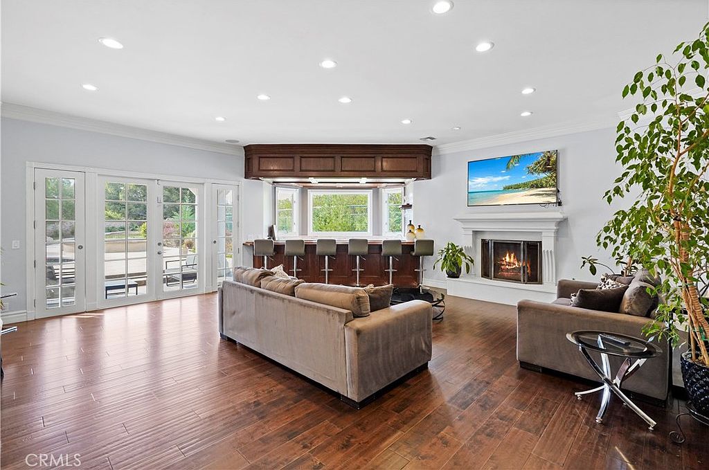 Family room with fireplace, wet bar and garden doors at 22510 La Quilla Dr, Chatsworth
