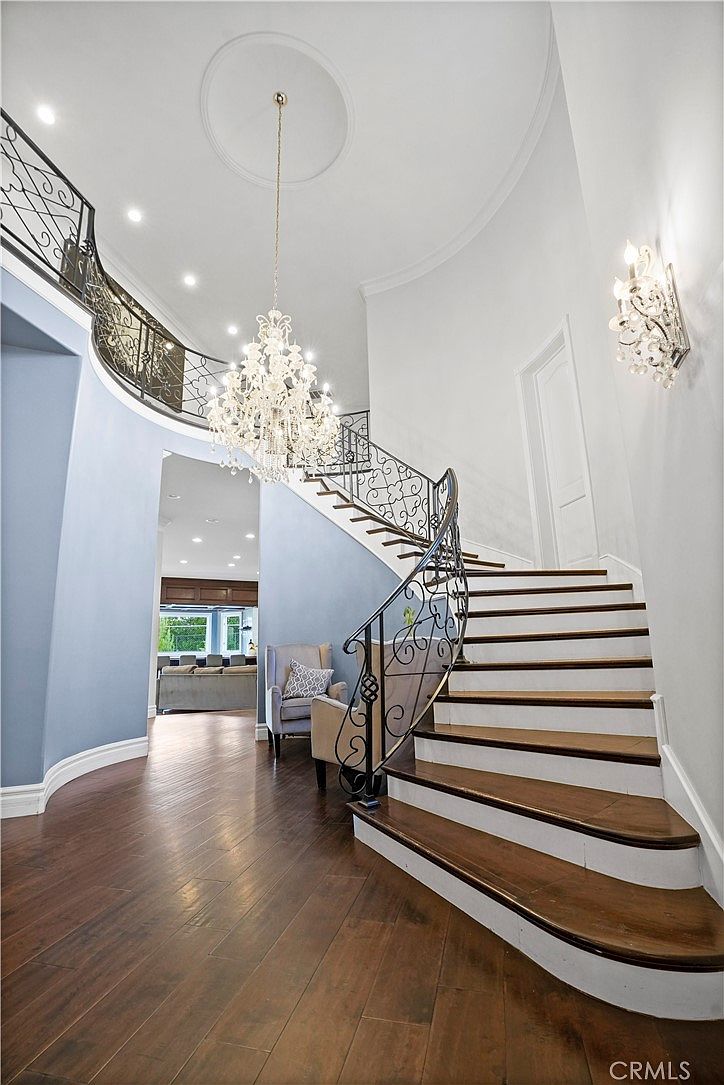 Curved staircase and chandelier from the landing at 22510 La Quilla Dr, Chatsworth