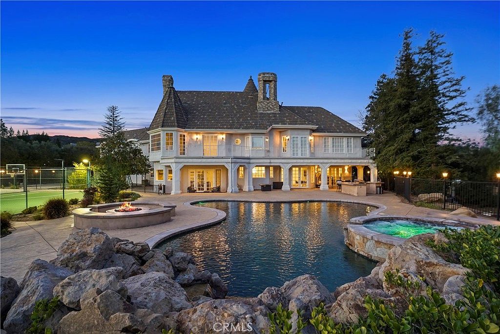 Rear elevation across the pool and spa at twilight at 22510 La Quilla Dr, Chatsworth
