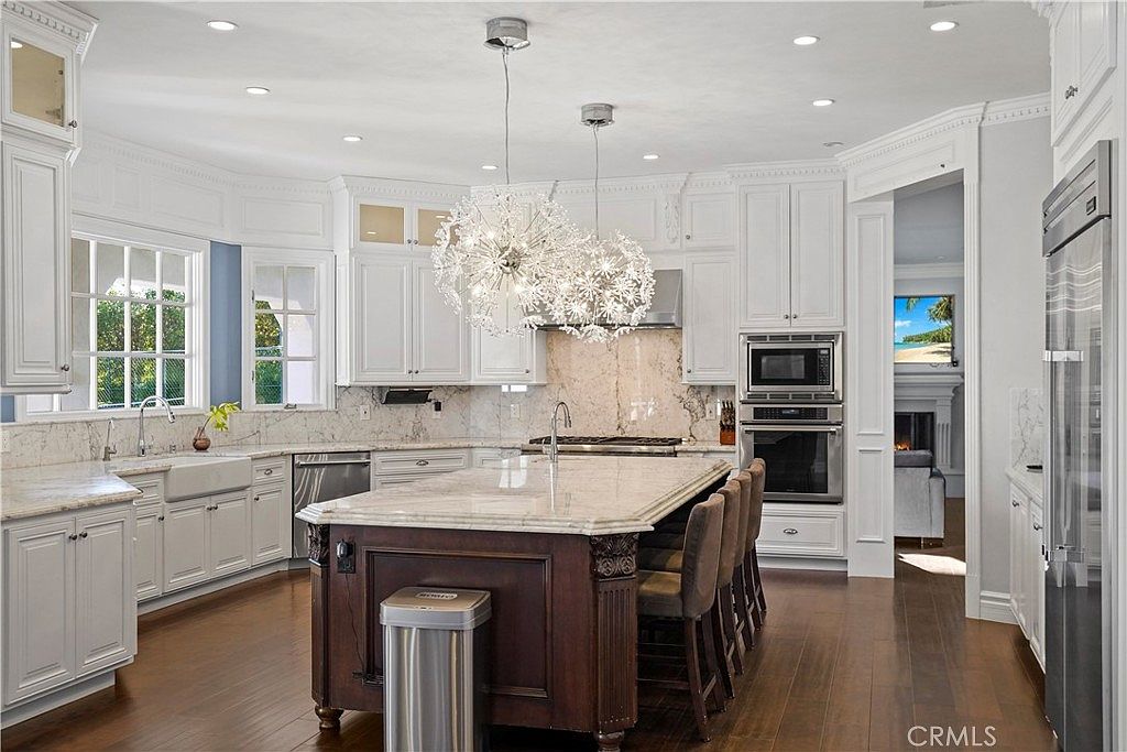 Chef's kitchen with marble island and dandelion pendants at 22510 La Quilla Dr, Chatsworth