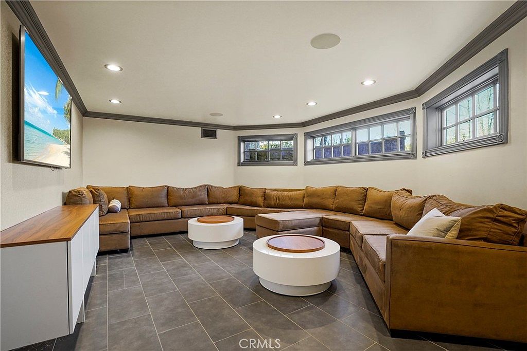 Lounge with wraparound sectional and bay windows at 22510 La Quilla Dr, Chatsworth
